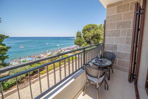 balkon ze stołem i krzesłami oraz widokiem na plażę w obiekcie Mar Azul Apartments Petrovac w Petrovacu na Moru