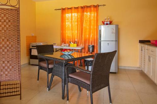 cocina con mesa, sillas y nevera en Alha Villa, en Baie Lazare Mahé