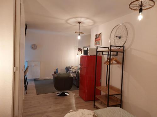een woonkamer met een rode koelkast en een bank bij Fahrradkeller in Melsungen
