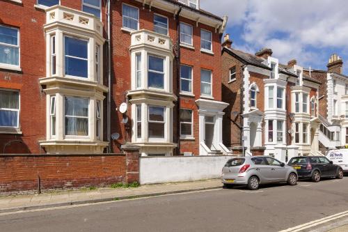 two cars parked in front of a brick building at Cormorant PLACE LUXURY PAD in Portsmouth