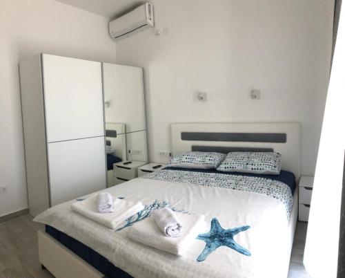 a bedroom with a bed with towels and a starfish at Apartmani Cupara in Tivat