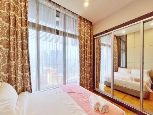 une chambre avec un lit et une grande fenêtre dans l'établissement Nana's at Dorsett Residence Bukit Bintang, à Kuala Lumpur