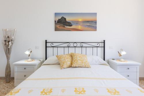 una camera con un letto bianco con due comodini di Pintadera B&B a Cagliari