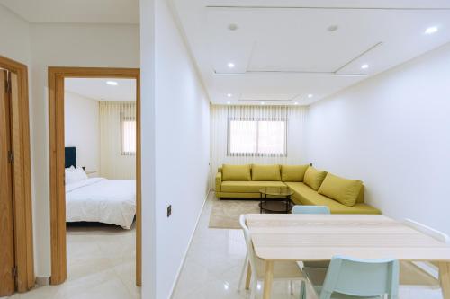 a living room with a yellow couch and a bed at EL NIDO ALHOCEIMA in Al Hoceïma