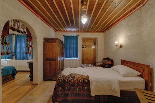 a bedroom with a large bed with a wooden ceiling at Yoruk Stone House in Nevsehir