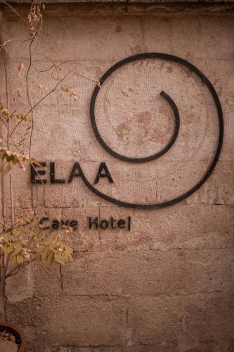 a sign for a hotel on a stone wall at Elaa Cave Hotel in Ortahisar