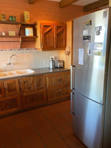 a kitchen with a stainless steel refrigerator and wooden cabinets at Kite View 2 Holiday Home in Witsand