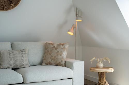 a living room with a blue couch and a lamp at Hotel Paradis Zandvoort in Zandvoort