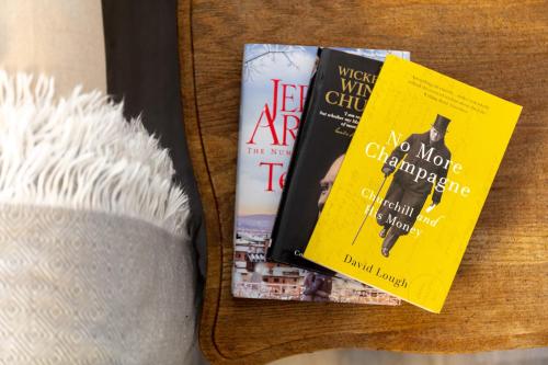 two books sitting on a table next to a hat at 9A Millbrae - Donnini Apartments in Ayr