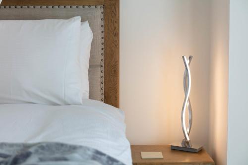 a lamp on a night stand next to a bed at 9A Millbrae - Donnini Apartments in Ayr