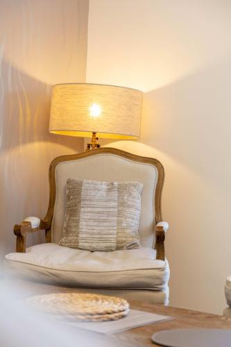 a lamp sitting on top of a table with a chair at 9A Millbrae - Donnini Apartments in Ayr