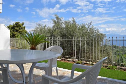 a patio with a table and chairs and a fence at Corinthian Gulf View in Egira