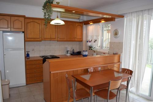 a kitchen with a wooden table and a table and chairs at Corinthian Gulf View in Egira