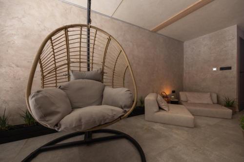 a wicker chair in a living room with a couch at Apartmány Na Lánech in Litomyšl