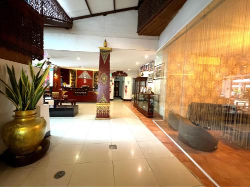a lobby of a building with a vase on the floor at Silver Resortel in Patong Beach