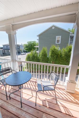 a patio with a table and chairs on a porch at Les résidences touristiques Victoria in La Baie