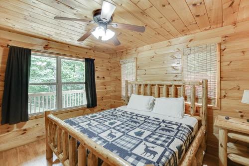 a log cabin bedroom with a bed and a ceiling fan at Listen to Chattahoochee RiverSleeps 8Near Helen in Sautee Nacoochee