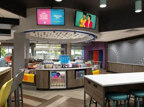 um restaurante de fast food com mesas, cadeiras e televisões em Tru By Hilton Indianapolis Lawrence, In em Indianápolis