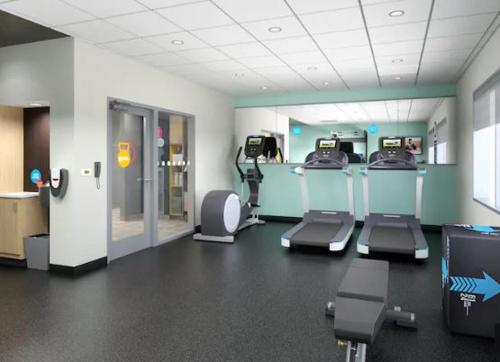 a gym with treadmills and machines in a room at Tru By Hilton Indianapolis Lawrence, In in Indianapolis