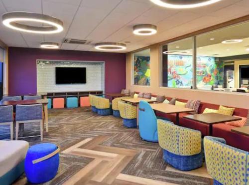 a restaurant with tables and chairs and a flat screen tv at Tru By Hilton Indianapolis Lawrence, In in Indianapolis