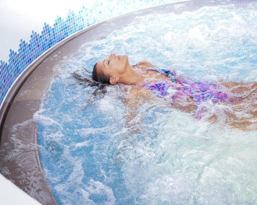 a young girl is swimming in a pool at Hotel Alba Wellness & Spa in Canazei
