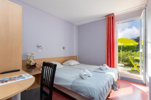 ein Schlafzimmer mit einem Bett, einem Schreibtisch und einem Fenster in der Unterkunft Village Vacances Le Junka in Vieux-Boucau-les-Bains
