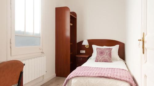 バルセロナにあるオスタル オリヴァの小さなベッドルーム(紫色の枕付きのベッド付)