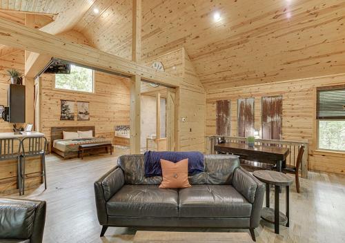a living room with a leather couch and a piano at Cabin Near Helen, GA w Spa Amenities in Cornelia