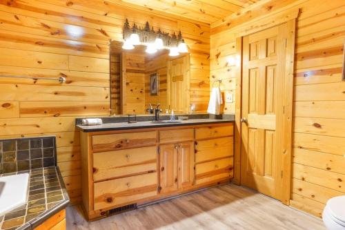 a bathroom with a sink in a wooden cabin at Cozy Creekside Log Cabin w Firepit, Hot Tub, WIFI in Cleveland