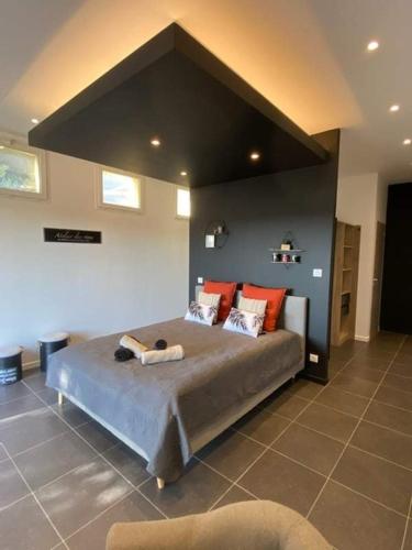 ein Schlafzimmer mit einem großen Bett mit roten Kissen in der Unterkunft chambre cocooning in Marseillan