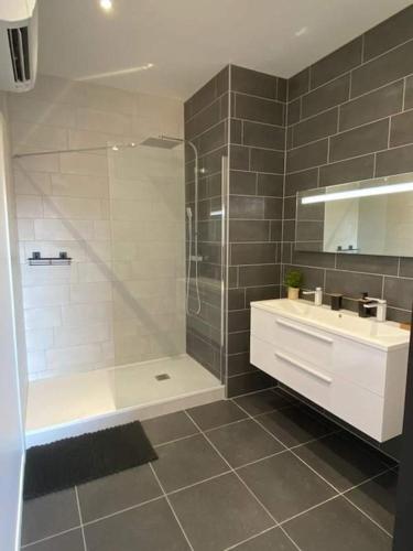 uma casa de banho com um chuveiro e um lavatório. em chambre cocooning em Marseillan