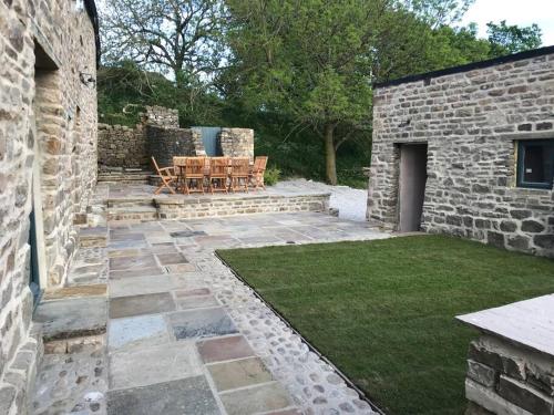 a patio with a table and chairs in a yard at Fremington Hall Farm, Reeth, Swaledale in Reeth