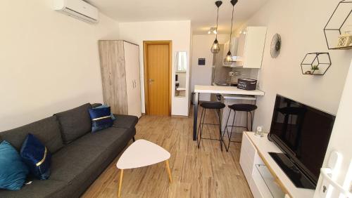 een woonkamer met een bank en een keuken bij Studio apartman Kiara in Bol