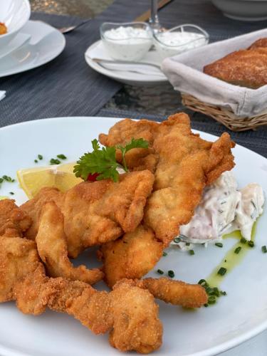 a plate of food with chicken tenders and dip at Budapest Airport Eprespark Hotel in Vecsés