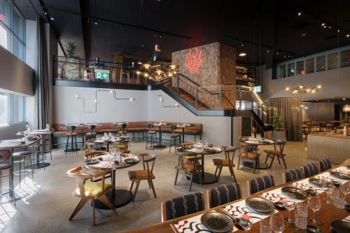 a restaurant with tables and chairs and a staircase at Hotel Indigo Brisbane City Centre by IHG in Brisbane