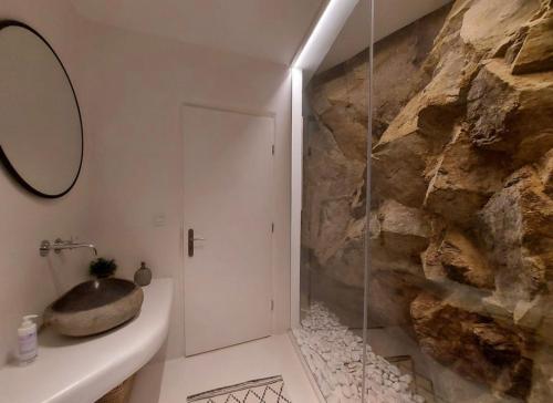 La salle de bains est pourvue d'une douche et d'un mur en pierre. dans l'établissement Ria Mar Lion, à Mykonos