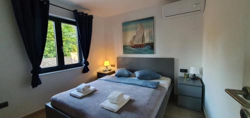 1 dormitorio con 1 cama con 2 toallas en Holiday house Manoka, en Mali Lošinj