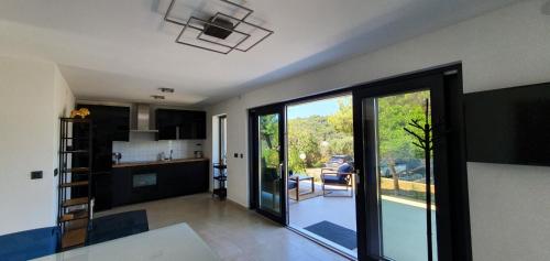 a kitchen with a large glass door leading to a patio at Holiday house Manoka in Mali Lošinj