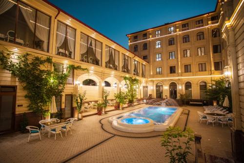 une cour avec une piscine au milieu d'un bâtiment dans l'établissement Konstantin Plaza, à Samarcande