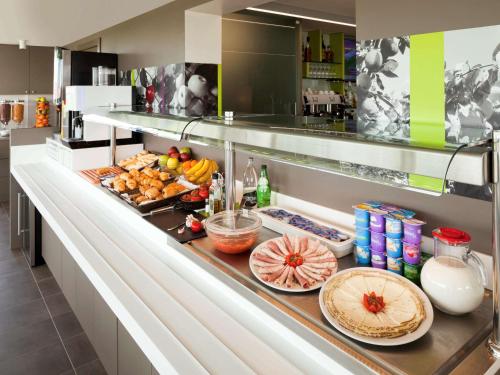 a kitchen counter with a bunch of food on it at Hotel Ibis Styles Lleida Torrefarrera in Lleida