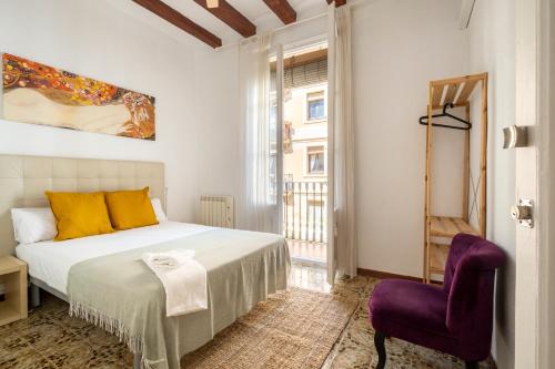 um quarto com uma cama e uma cadeira roxa em CENTRIC APARTMENT GAUDI em Barcelona