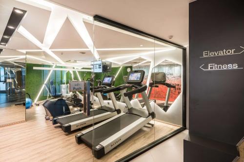 a gym with treadmills and ellipticals in a building at Vib Best Western Sanam Pao in Bangkok
