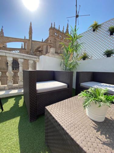 eine Terrasse mit 2 Stühlen und einem Tisch mit Pflanzen in der Unterkunft Catedral Boutique in Sevilla