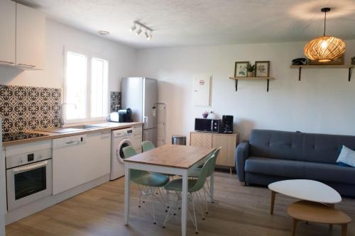 a kitchen and living room with a table and a couch at L'Instant Provence in Valréas
