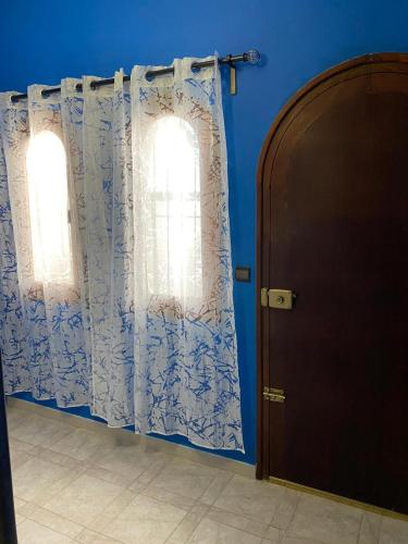 two windows with curtains in a room with blue walls at Casa Cabo Negro in Cabo Negro