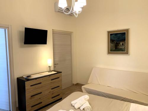 a bedroom with a bed and a television on the wall at Domo Achenza in Terralba