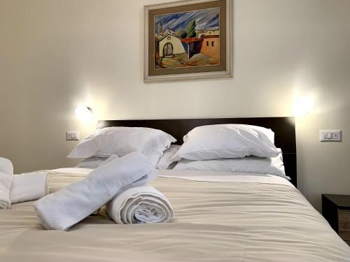 two beds with white pillows and a picture on the wall at Domo Achenza in Terralba