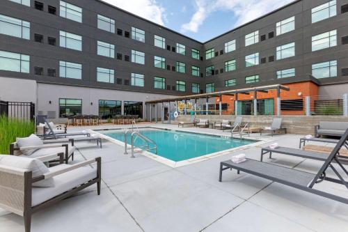 a swimming pool in front of a building at Cambria Hotel Austin Airport in Austin