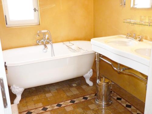 a bathroom with a tub and a sink at La Tour D'Orgueil in Mallemort