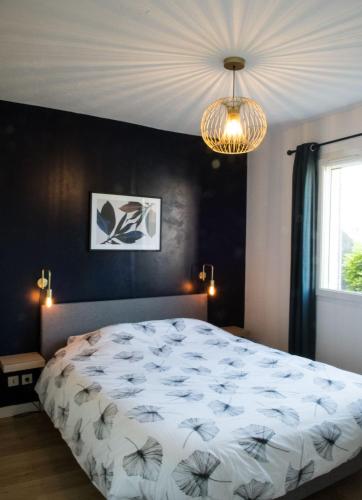 a bedroom with a large bed and a chandelier at L'Instant Provence in Valréas